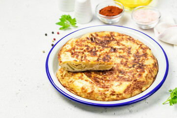 Spanish tortilla, potato onion omelette on light background. Space for text.