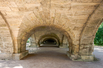 Fototapeta na wymiar Arched stone bridge in the park.