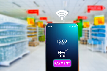 Payments using smartphone. Electronic payment for goods. Payments in the mobile app. Contactless payment for goods. A smartphone with a payment system on the background of a blurry image of the store.
