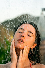 Beauty portrait of attractive woman with water drops of tropical shower. Spa procedures for hygiene care.