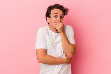 Young caucasian man isolated on pink background scared and afraid.