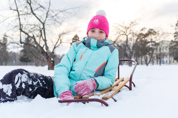 Teengae girl having fun playing with the sledge in the snow in winter