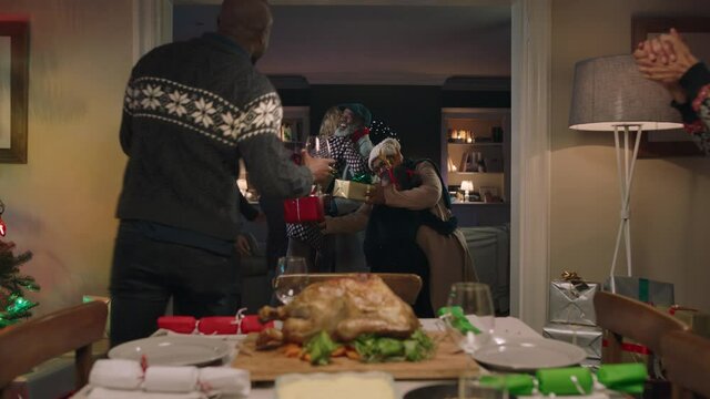 christmas dinner african american family hugging friends arriving for party celebrating festive holiday reunion enjoying season greeting at home 4k footage