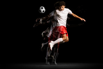 Stroboscope effect. One man, professional football player isolated on black background playing