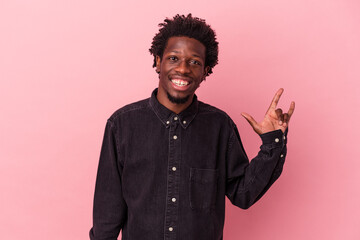 Young african american man isolated on pink background showing a horns gesture as a revolution concept.