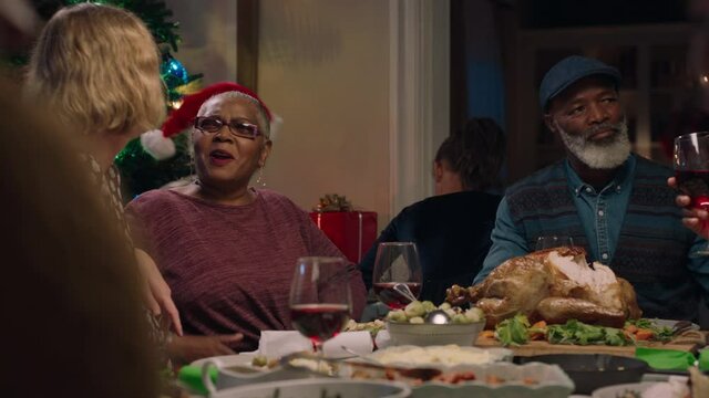 young woman celebrating christmas dinner with african american family sharing festive holiday meal together at home 4k