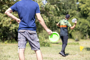 Playing flying disc golf sport game in the park