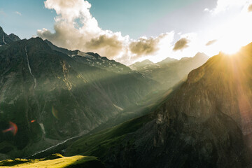 Beautiful mountain landscape on a summer evening, the sun's rays illuminate the mountain green valley and rocky slopes before sunset - obrazy, fototapety, plakaty