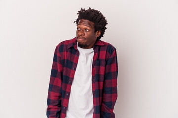 Young african american man isolated on white background  shrugs shoulders and open eyes confused.