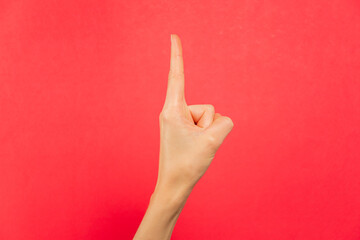 Mano señalando con el dedo índice. Fondo rojo