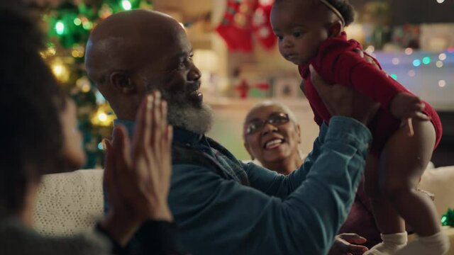 african american family christmas grandfather holding baby girl giving kiss proud of granddaughter happy grandparents enjoying festive holiday reunion at home 4k