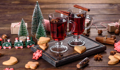 Fototapeta na wymiar Christmas mulled red wine with spices and fruits on a dark table.