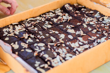 Naklejka na ściany i meble Brownies topped with almonds in a large paper tray.