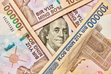 US dollar banknote and Uzbek sums. Concept of exchange rate, Uzbek sum to us dollar. Money exchange in Uzbekistan. Pile of Uzbek money sum and American dollar bill
