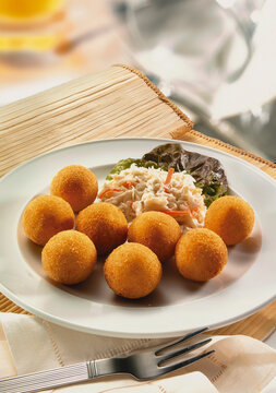 Plato de croquetas de marisco con ensalada para compartir. Plate of seafood croquettes with salad to share.