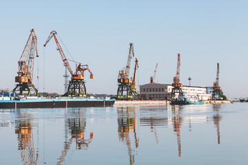 Fototapeta na wymiar Port cranes stand at the pier in Ruse port, Danube river