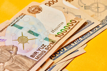 Macro shot of uzbek sum banknote. Pile of Uzbek sums. Uzbek currency money bill. A stack of one hundred thousand Uzbek sum. 100000 sum - obrazy, fototapety, plakaty