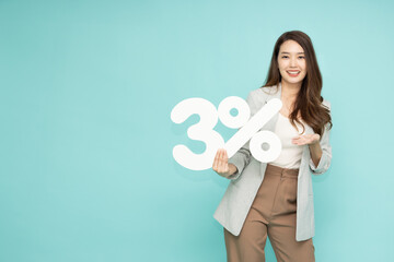 Portrait of Asian business woman showing and holding 3% number or three percent isolated over green...