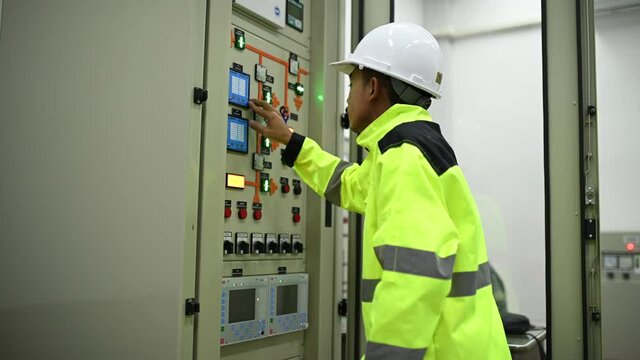 Electrical engineer man checking voltage at the Power Distribution Cabinet in the control room,preventive maintenance Yearly,Thailand Electrician working at company