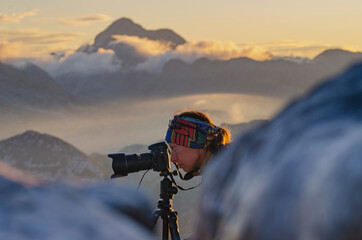Woman photographer takes photos high in the mountains
