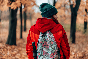 Attractive caucasian traveler with backpack relaxing by autumn forest