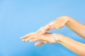 Persona lavándose las manos, desinfección de manos. Fondo azul