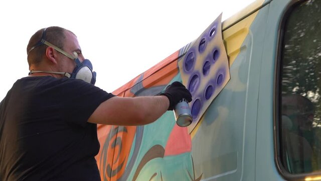 international artist day.graffiti artist stencil painting a van