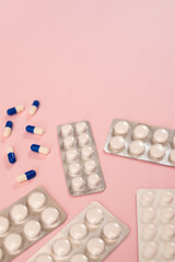 Some different pills and envelope of pills on a pink background with copy space 