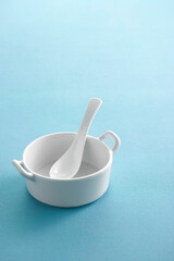 Ceramic spoon in cup on pastel background