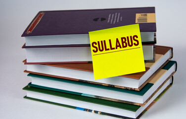 SULLABUS - word on a yellow piece of paper against the background of textbooks