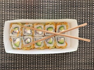 Sushi con palillos en toma cenital sobre mantel