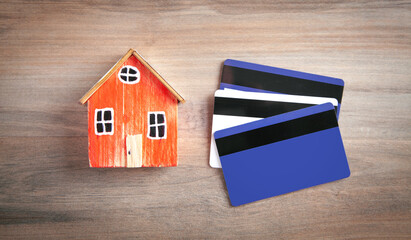 House model and credit card on the wooden table.