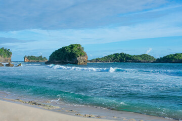 Fototapeta na wymiar A beach with a small island with sunny weather.