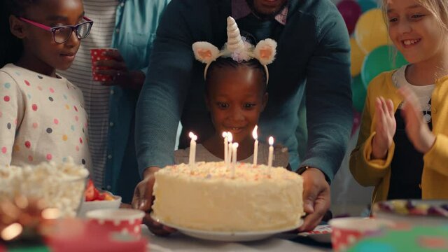 african american birthday girl blowing candles on cake making wish celebrating party with friends children having fun celebration at home 4k footage