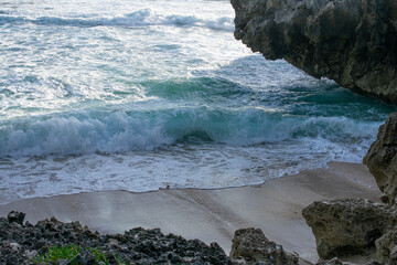 Sea waves between the rocks on the beach.