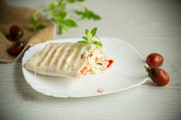 baked pita roll with filling in a plate on the table