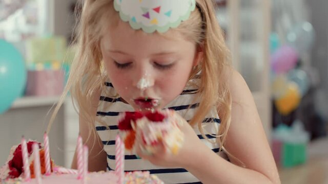 greedy girl eating birthday cake naughty child overeating taking mouthful excessive hunger at party 4k footage
