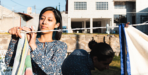 Young smiling couple hanging out clothes