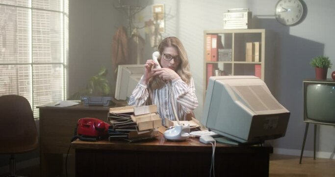 So busy. Full length view of the blonde female worker having a lot of calls. Business woman answering phone calls on many telephones. Retro office concept