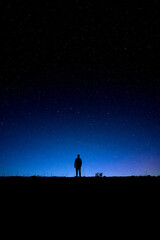 Silhouette of a man stargazing at the stars during the night