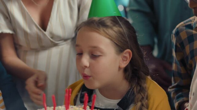 happy birthday girl blowing candles on cake making wish celebrating party with family and friends children having fun celebration at home 4k footage
