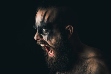 Portrait of a Viking warrior with black war paint, screaming with rage and anger - obrazy, fototapety, plakaty
