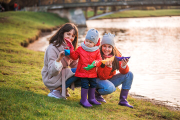 Fototapeta premium child playing with paper boats in spring water.lake or river