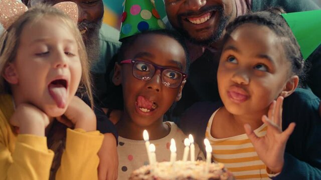 happy girl blowing candles on birthday cake making wish celebrating party with best friends children having fun celebration at home 4k footage