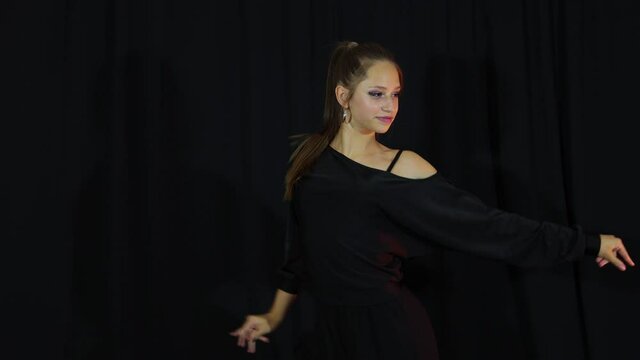 Girl in black cloth actively dance latine