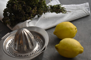 Exprimidor metalico, limones y flor de romero