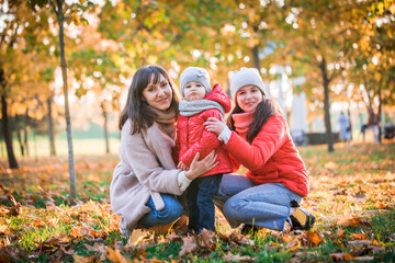 Mother and her child girl playing together on autumn walk in nature outdoors.Active games of happy family, lifestyle in autumn yellow park.movement, defocus, selective focus
