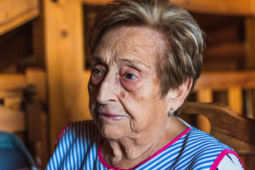 elderly woman sitting on a chair while watching