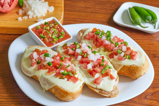 Molletes, t&iacute;pica comida mexicana con salsa pico de gallo, frijoles y queso manchego para el desayuno o comida.