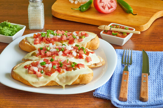 Molletes, t&iacute;pica comida mexicana con salsa pico de gallo, frijoles y queso manchego para el desayuno o comida.